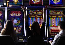 Pemain memegang smartphone dengan aplikasi hiburan sports dan casino online di layar